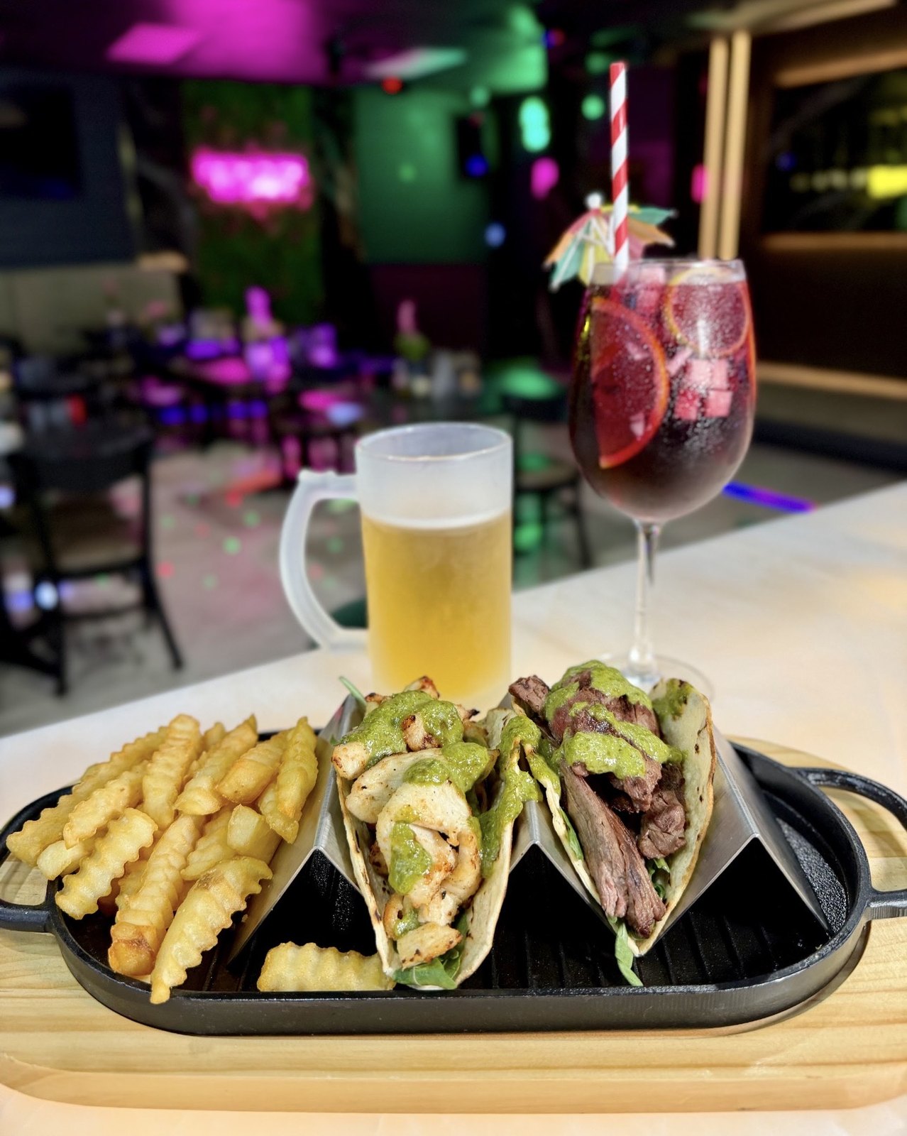 Chicken and steak tacos on a cast iron skillet with beer and sangria